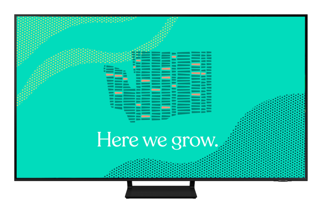 Colorful digital display featuring a stylized map of Washington State with the phrase "Here we grow" prominently displayed, emphasizing growth and progress in a vibrant design.