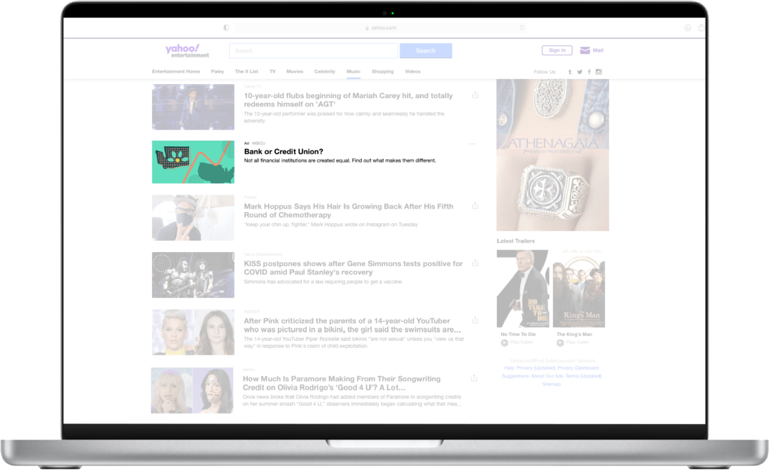 Laptop displaying a search engine results page featuring news articles, videos, and images related to popular topics and current events.