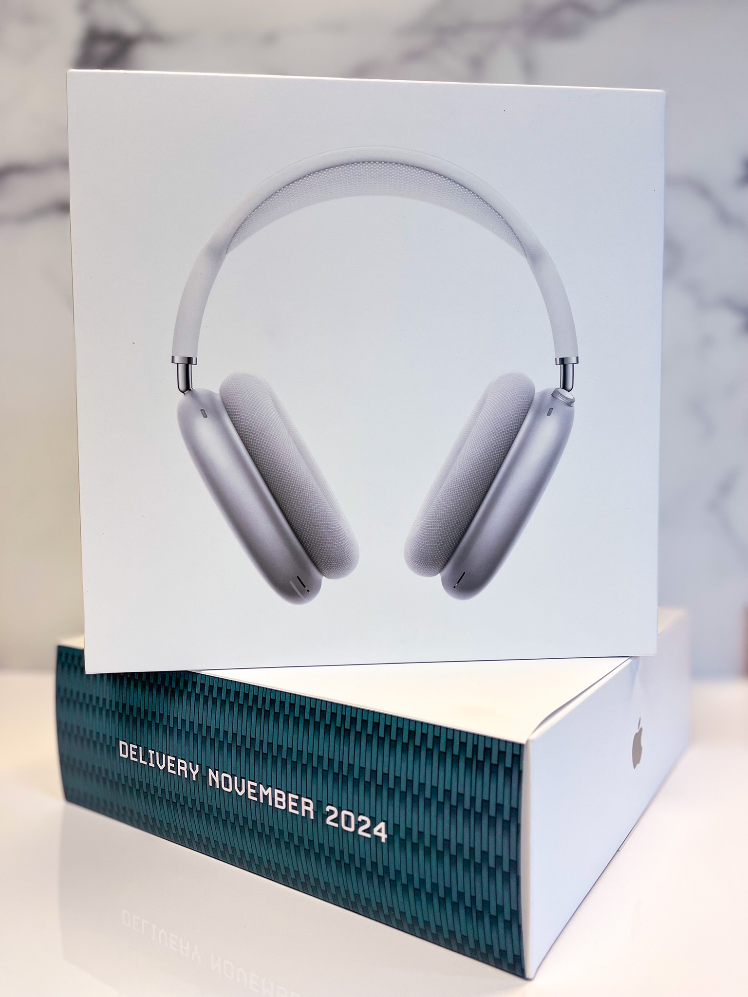 White over-ear headphones displayed in their packaging, featuring a sleek design and the label "Album Journey 2024" on the box.