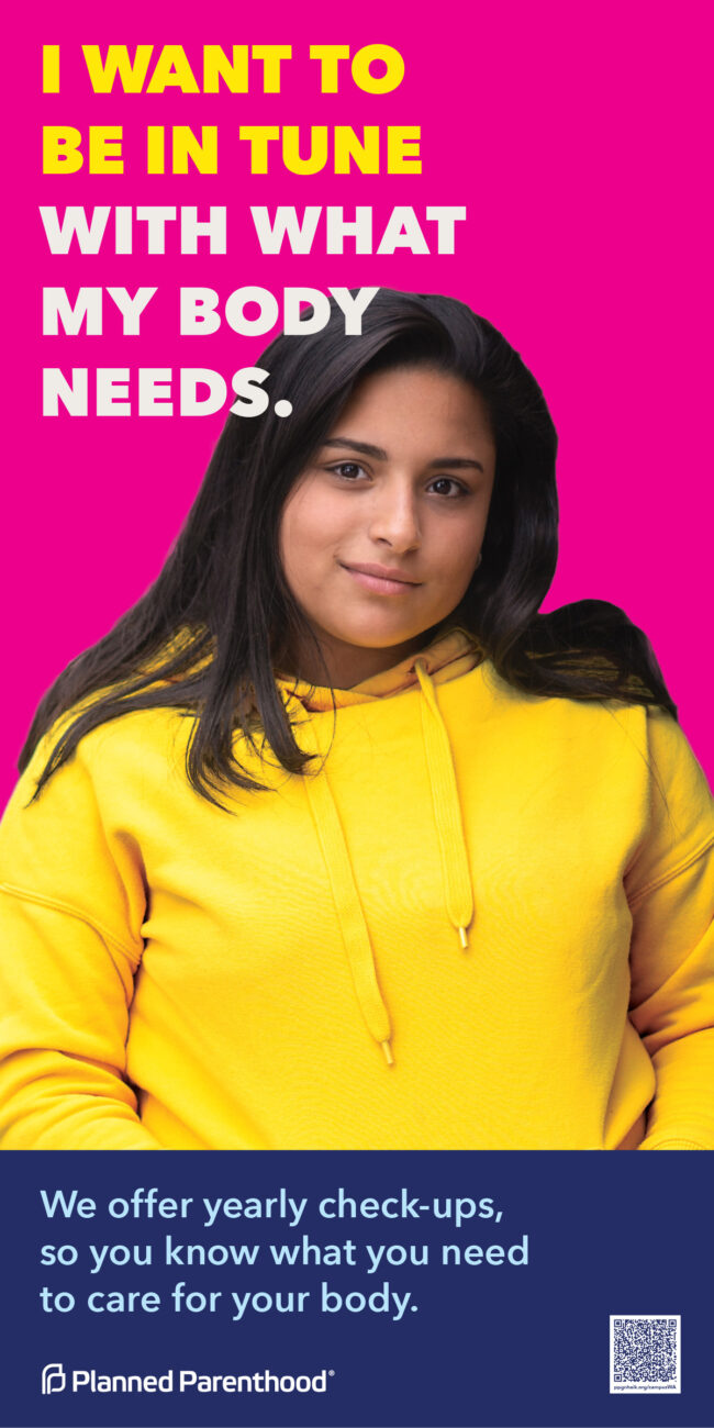 Young woman in a bright yellow hoodie poses confidently against a vibrant pink background, emphasizing empowerment and self-expression.