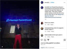 A person stands in front of a Planned Parenthood building illuminated at night, promoting women's health and reproductive rights.