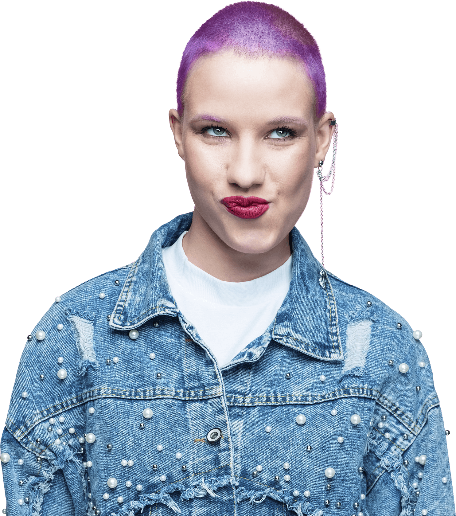 Young woman with short purple hair and bold red lipstick, wearing a denim jacket adorned with pearls, making a playful expression.
