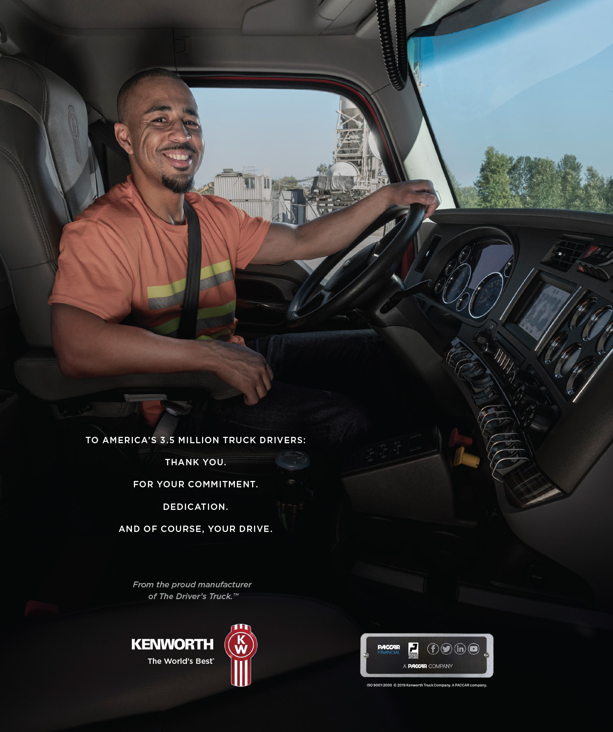 A truck driver seated inside a Kenworth truck cabin, smiling and looking confidently at the road ahead. The interior features modern controls and a spacious design, emphasizing comfort and functionality. The image conveys a message of appreciation to truck drivers for their dedication and hard work.